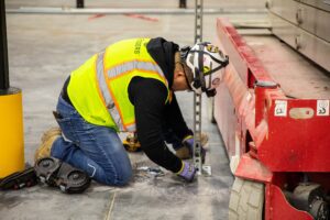 Electrician working on an electrical install inside a warehouse.