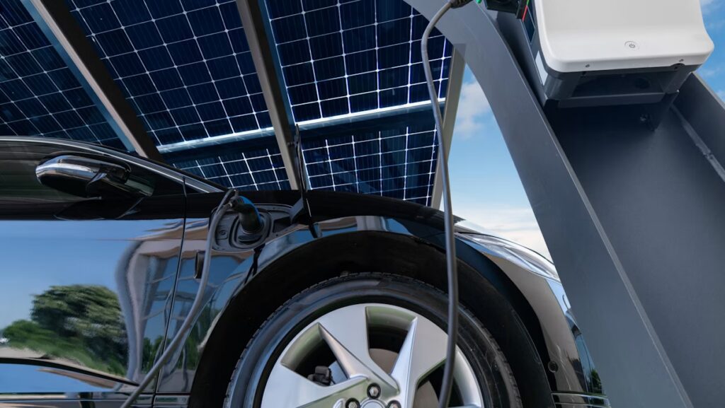 Black electric vehicle being charged by an EV charging installation.