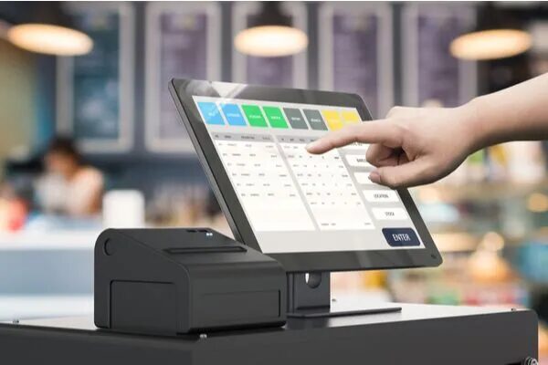 picture of hand touching a retail POS system with blue, green, black, and yellow squares