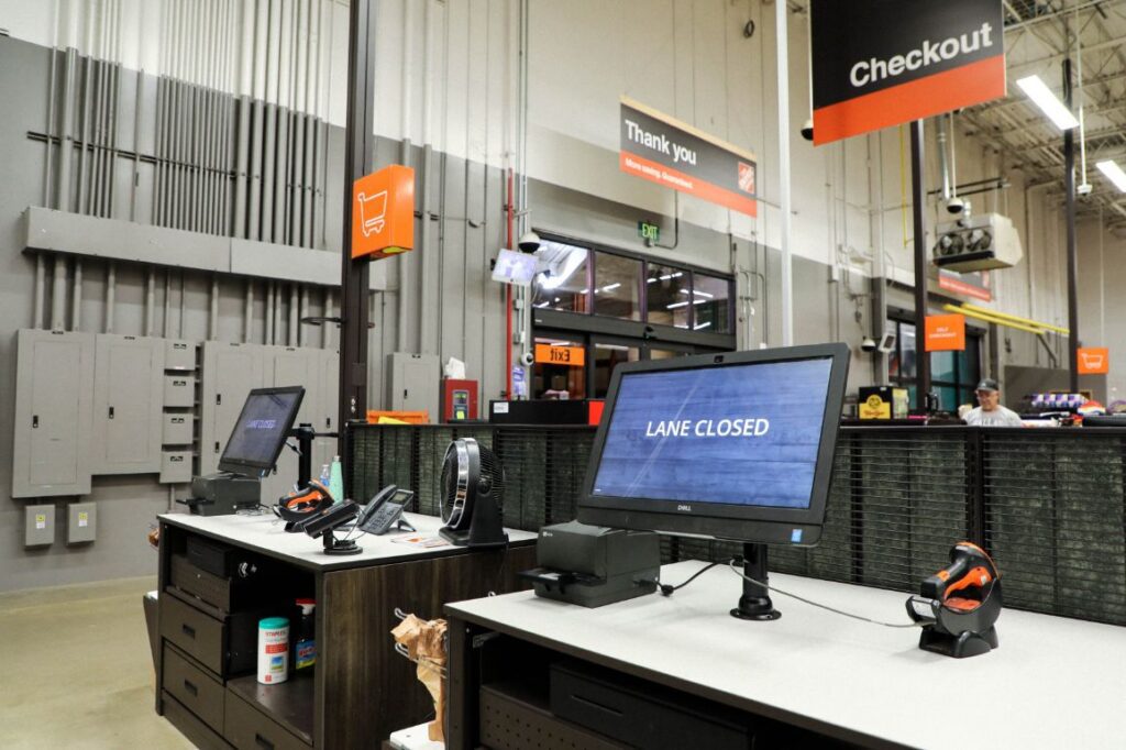 Picture of front of store of Home Depot with signs that read Checkout and Thank you and a POS checkout system that says Lane Closed