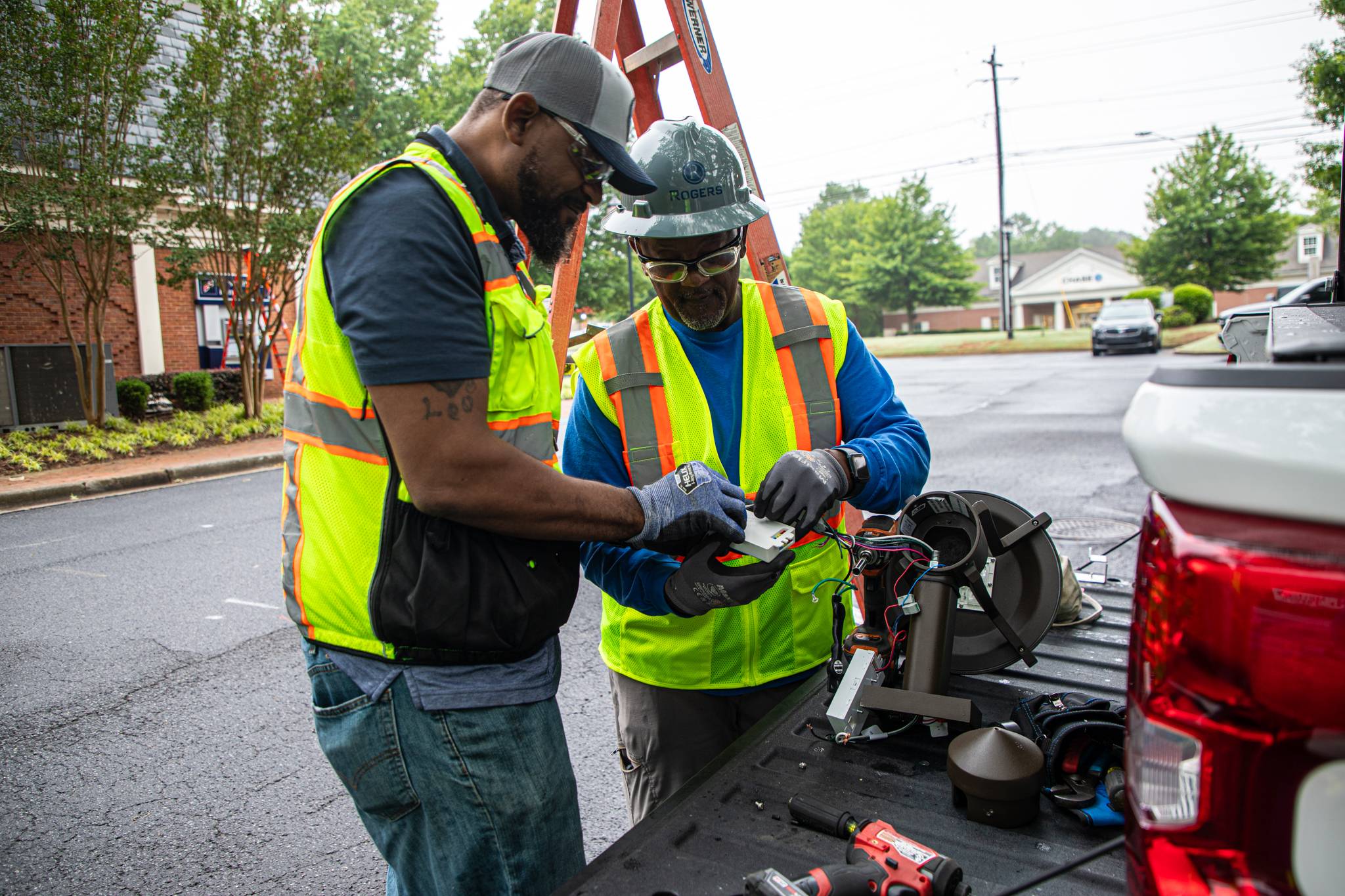 Technicians working on light fixture before installing.