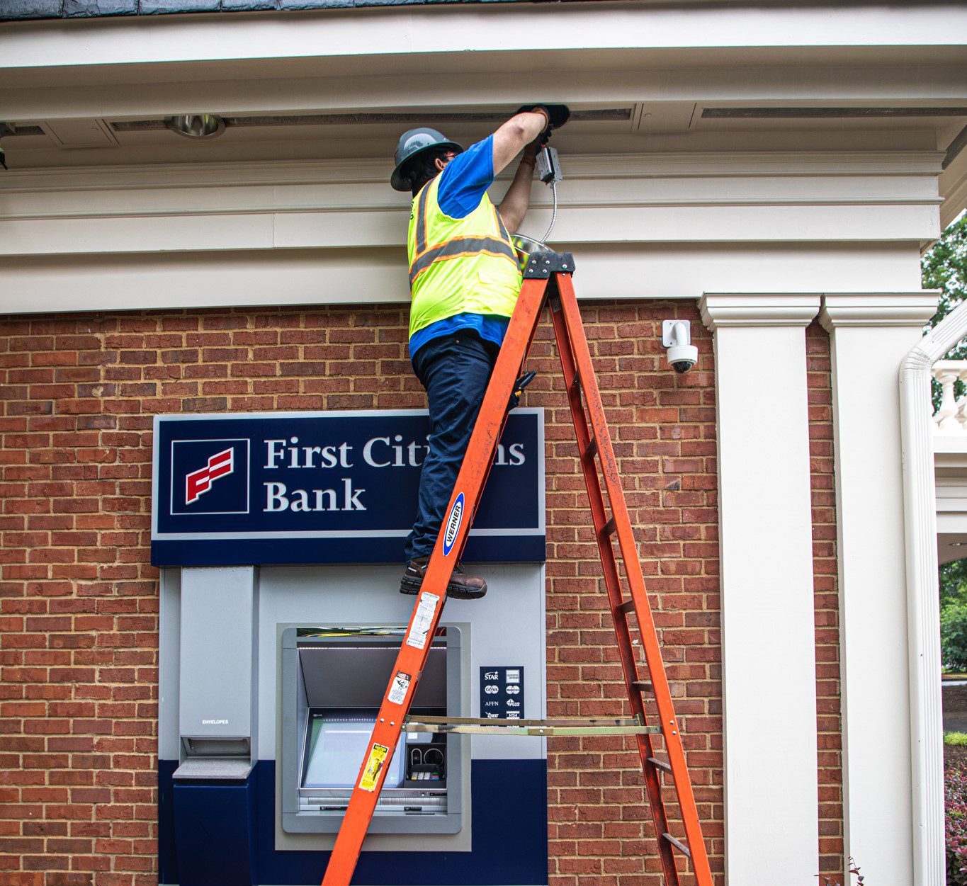 Rogers technician on ladder installing new can light.