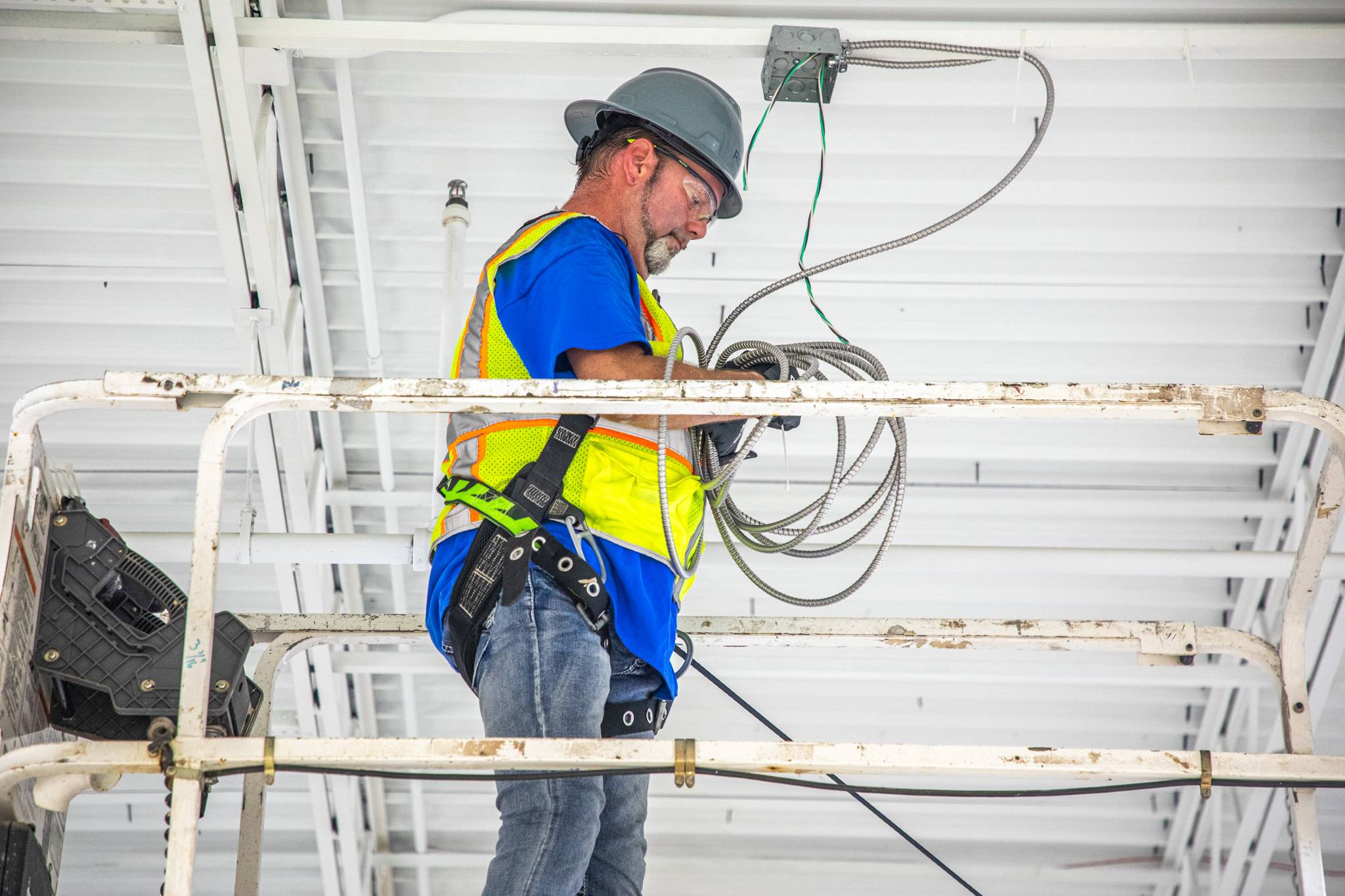 Staples - 2 Rogers technician preparing wire to route from ceiling to device table.