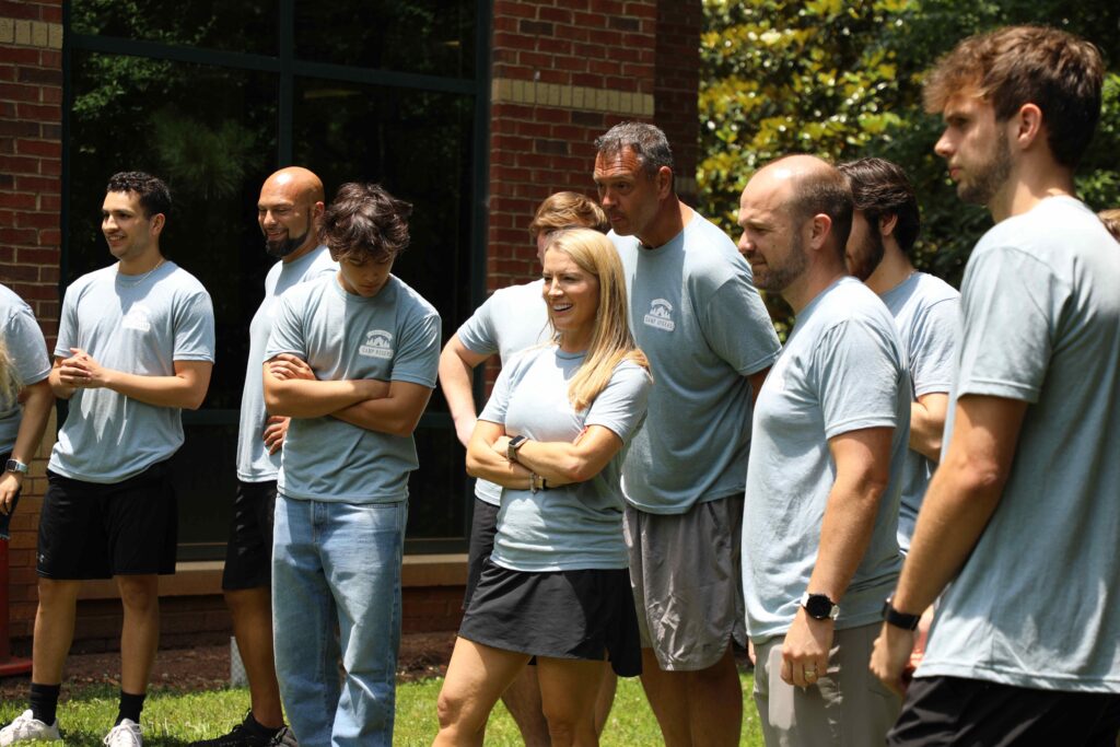 a group of Rogers Electric employees standing outside together smiling in blue t-shirts