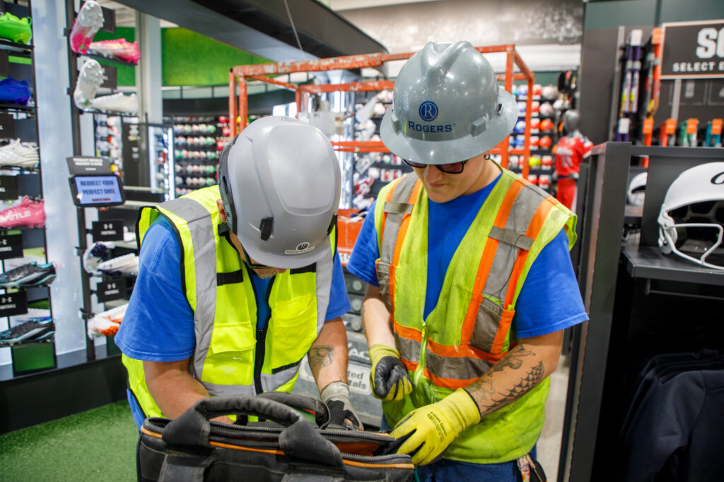 Rogers Electric electricians installing electrical systems inside a Dick’s Sporting Goods House of Sport location.