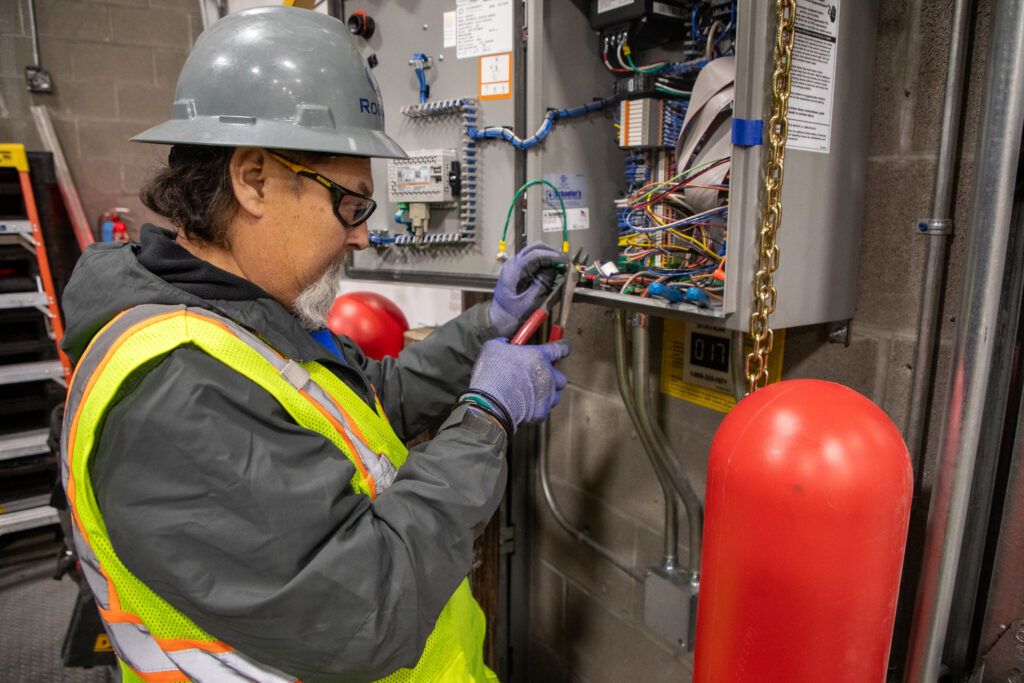 Electrician installing and organizing wiring to support electric-powered building systems